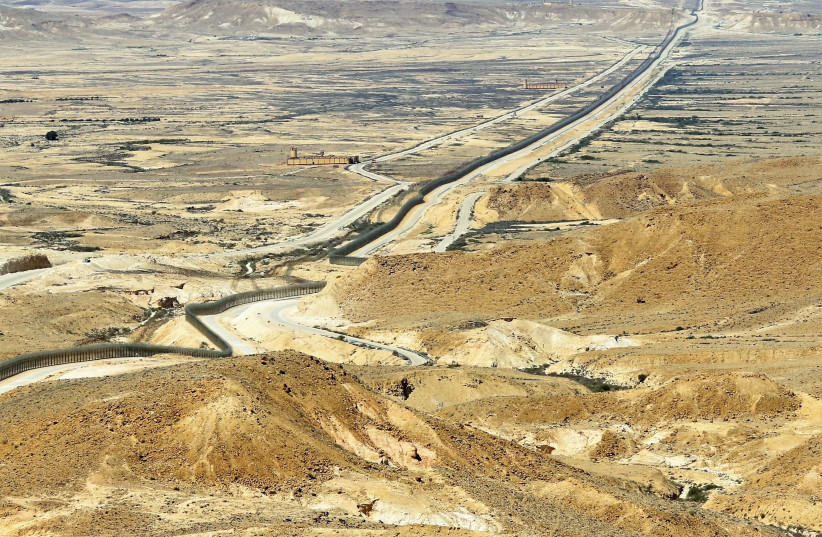 THE BORDER fence cuts across the arid landscape. Looking north, Egypt and the Sinai Desert are to the left of the fence and Israel and the Negev Desert lie on its right.