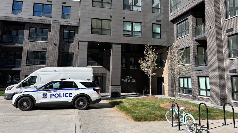 A police car is pictured in front of an apartment builidng.