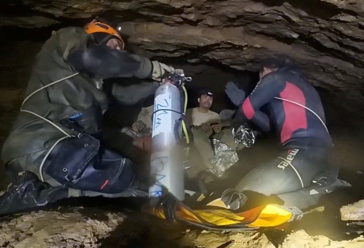 An image from a video provided by Norrased “Benz” Palasing of SeaScout Diving shows a rescue team training people trapped in a semi-submerged cave how to use diving equipment before the first of them was freed, on Friday in Xaysomboun province of Laos. (Photo via Reuters)