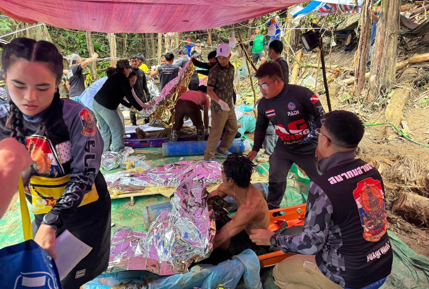 Volunteers tend to the four men brought out of the cave located 120km northeast of Vientiane on Saturday afternoon. (Photo: Thailand Rescue Diver Facebook)