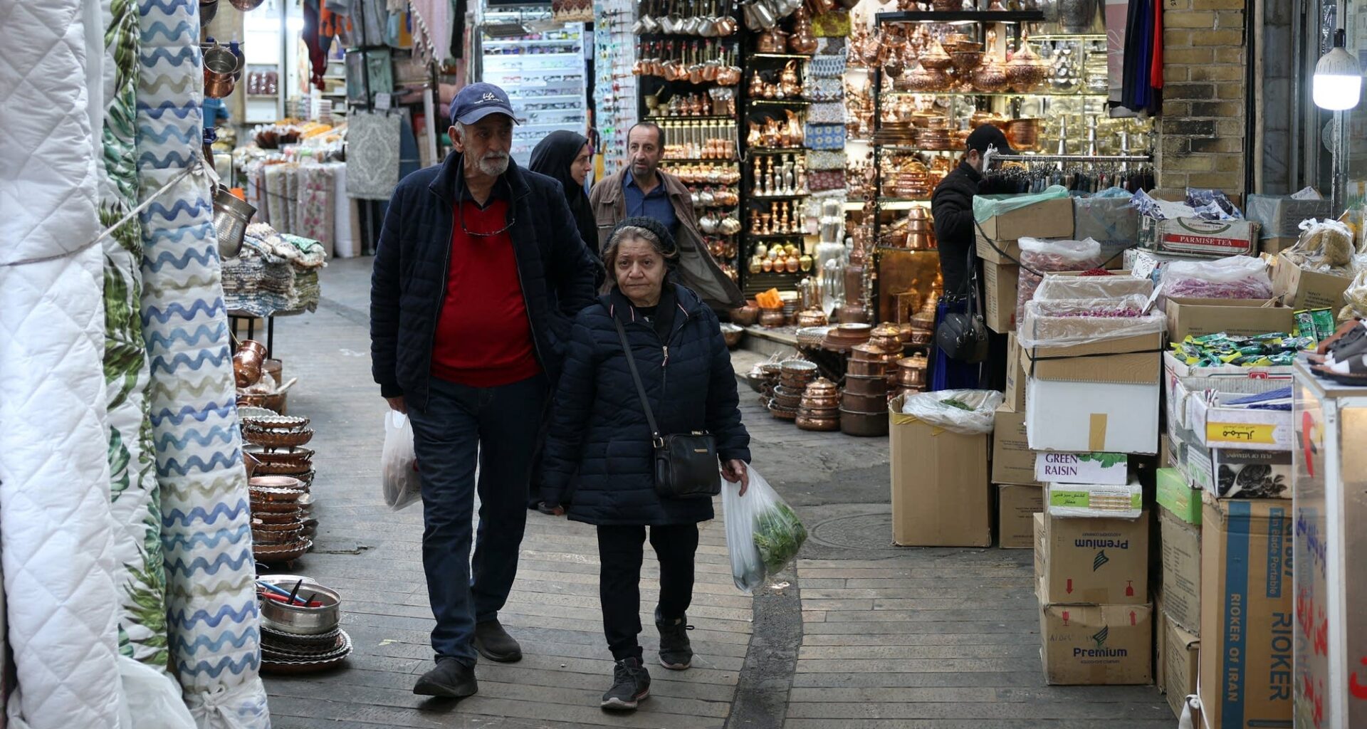 Above, Iranians shop at Tajrish Bazaar in Tehran on March 24. The Iranian government has been providing people with cash handouts, but it's barely enough to buy daily food, said Virginia Tech's Djavad Salehi-Isfahani.