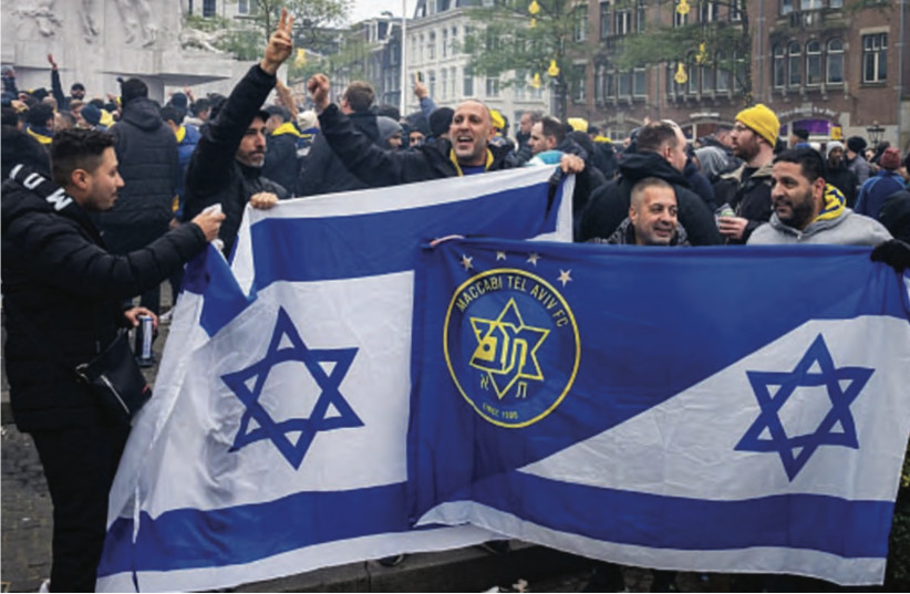 Supporters of Maccabi Tel Aviv hold flags at Dam Square ahead of the Europa League football match between Ajax and Maccabi Tel Aviv, in Amsterdam on November 7, 2024