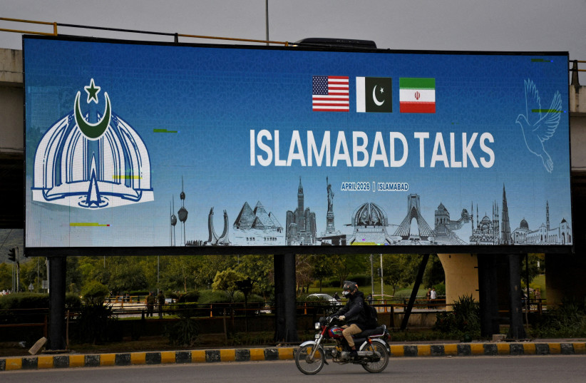 A man rides his motorbike past a billboard installed alongside a road as Pakistan prepares to host the U.S. and Iran for peace talks, in Islamabad, Pakistan, April 10, 2026.