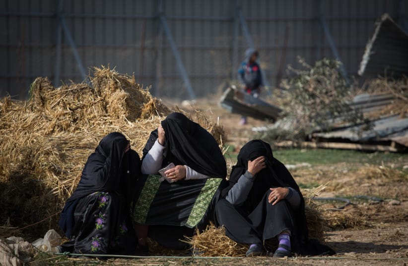 Bedouin women sit outside their demolished homes in the Bedouin village of Umm al-Hiran in the Negev desert, in the in the Southern Israel, January 18, 2017.