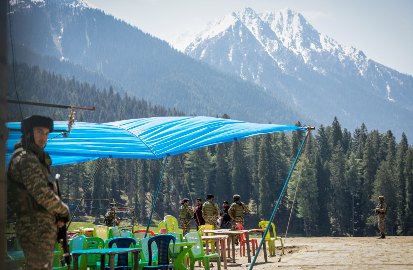 Indian security force personnel talks to the local people at the site of a suspected militant attack on tourists in Baisaran near Pahalgam in south Kashmir's Anantnag district, April 24, 2025.