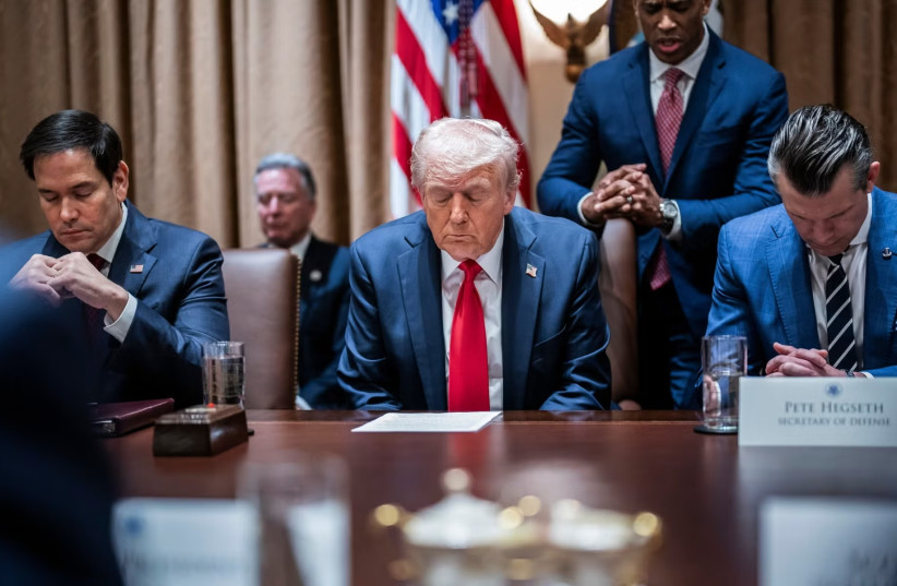 President Donald Trump prays at the first cabinet meeting of his second term at the White House in February, 2025