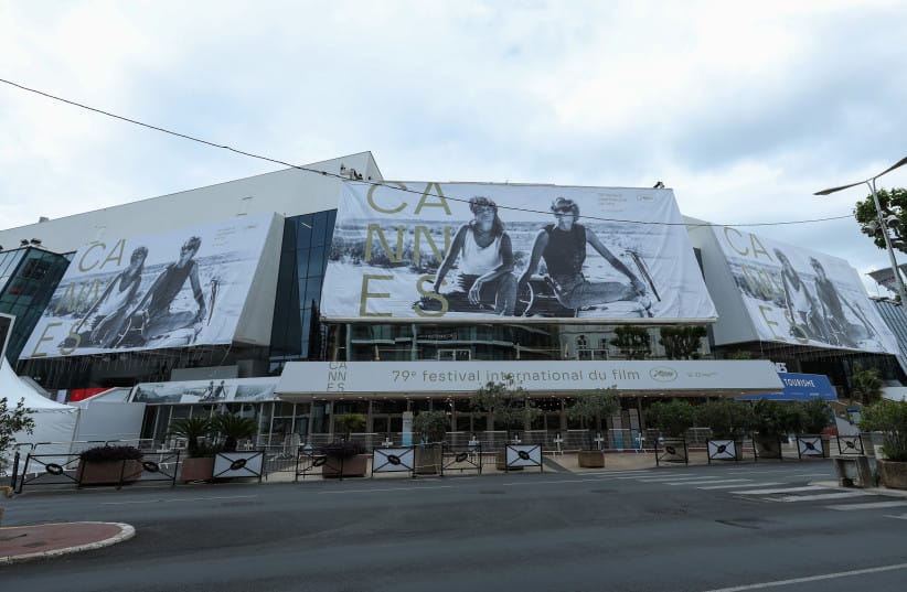 Workers install the official 2026 festival poster, featuring an image of Susan Sarandon and Geena Davis in ''Thelma & Louise'', during the 79th annual Cannes Film Festival on May 10, 2026 in Cannes, France.