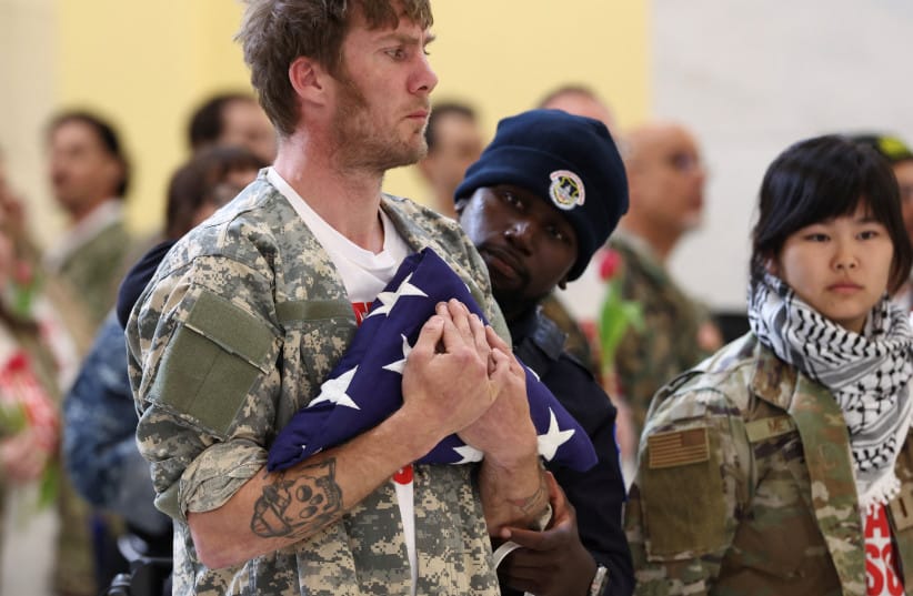 A veteran from the group About Face holds a symbolic burial flag to honor the dead as police arrest him during a protest against the Iran war, in the Cannon House Office Building Rotunda on Capitol Hill in Washington, DC, US, April 20, 2026.