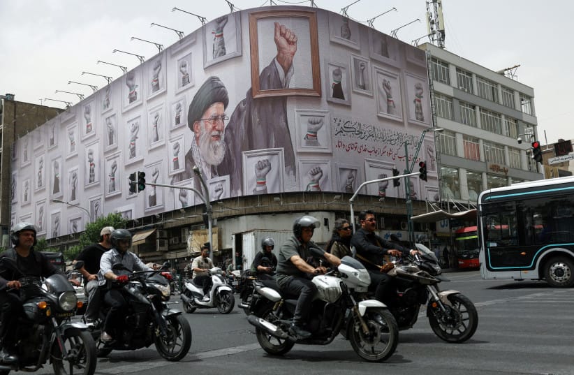 PEOPLE RIDE motorcycles near a billboard with an image of the late Iranian Supreme Leader Ayatollah Ali Khamenei, in Tehran, Iran, May 19, 2026. (credit: MAJID ASGARIPOUR/WANA
