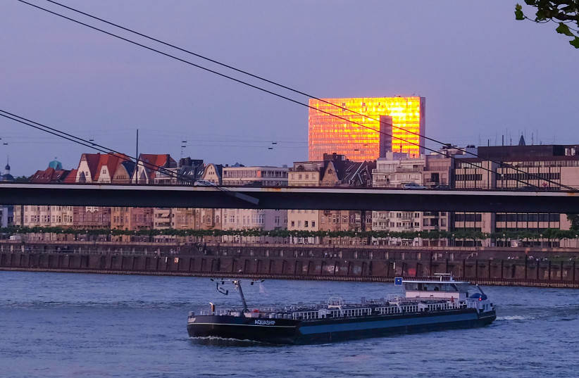 A barge maneuvers river Rhine with the Duesseldorf city skyline behind it as the sun sets in western Germany on May 28, 2018.