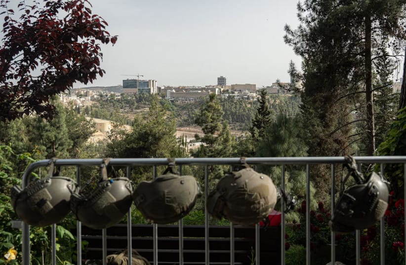 IDF soldiers' helmets are hung from a rail, with Jerusalem in the background, on Israel's Memorial Day on April 30, 2025 in Jerusalem, Israel.