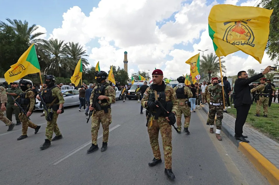 Members of Iraq’s pro-Iran paramilitary group Hezbollah Brigades (Kataeb Hezbollah) gather in a mourning procession for one of their comrades who was killed the previous day in a strike in Basra, during the funeral in Baghdad on April 8.