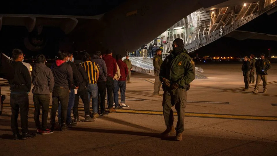 In this handout provided by the US Department of Defense, US Customs and Border Protection Agents guide immigrants onboard a C-17 Globemaster III at the Tucson International Airport in Arizona on January 23, 2025. - Senior Airman Devlin Bishop/DOD/Getty Images/File
