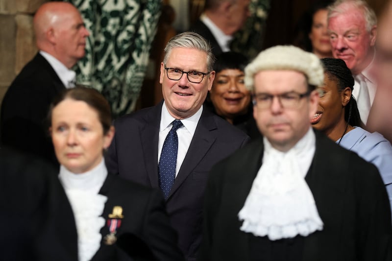 British prime minister Sir Keir Starmer smiles as he walks through the member's lobby of the Houses of Parliament in London to the House of Lords to hear king Charles' speech. Photograph: Toby Melville/PA Wire