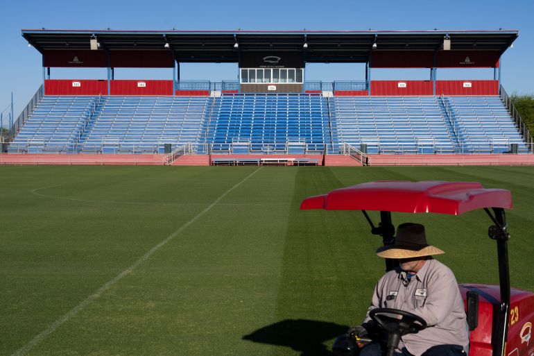A worker cuts the grass at the Kino Sports Complex, where Iran's national football team Team Melli will train during the 2026 FIFA World Cup, in Tucson, Arizona, on May 7, 2026. In the Strait of Hormuz, US warships menace Iran's oil tankers. In Washington, President Donald Trump threatens nothing less than "complete victory" will suffice. But in Tucson, they're getting ready to welcome the Iranian football team as if nothing were amiss. The city, an oasis of manicured lawns in the Arizona desert, is set to be the base camp for "Team Melli" when the world's biggest sporting spectacle opens in the US, Mexico and Canada next month. (Photo by Rebecca NOBLE / AFP)