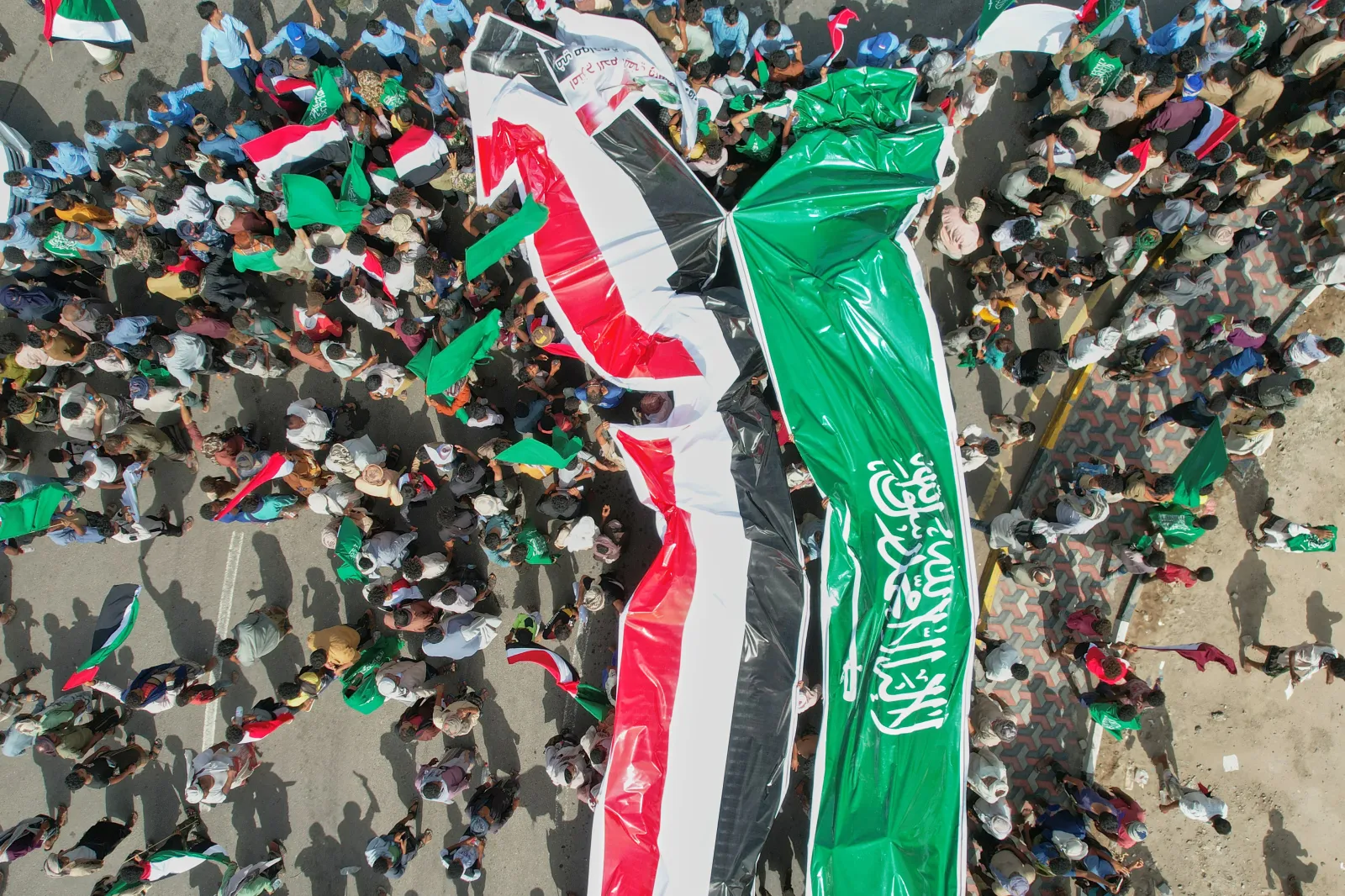 Yemenis raise Yemeni and Saudi flags during a march to protest Iranian attacks on Saudi Arabia, in the coastal town of Mokha, Yemen, on April 4. (AP Photo/Abdulnasser Alseddik)
