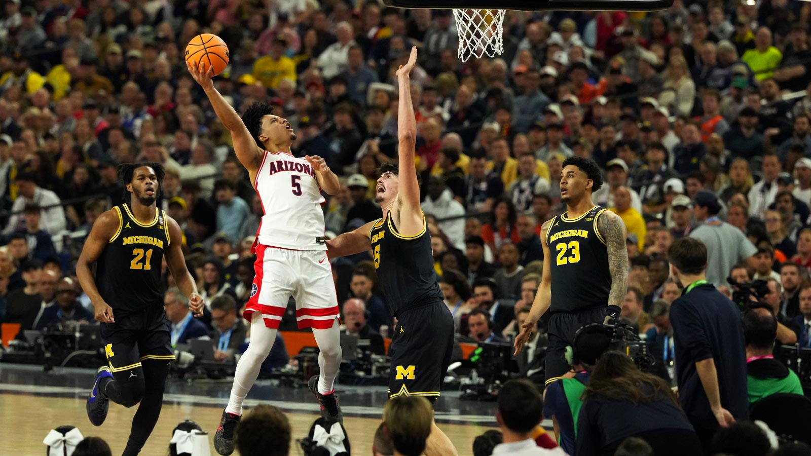 Arizona Wildcats guard Brayden Burries (5) shoots against Michigan Wolverines center Aday Mara (15) in the second half during a semifinal of the Final Four of the men's 2026 NCAA Tournament at Lucas Oil Stadium.