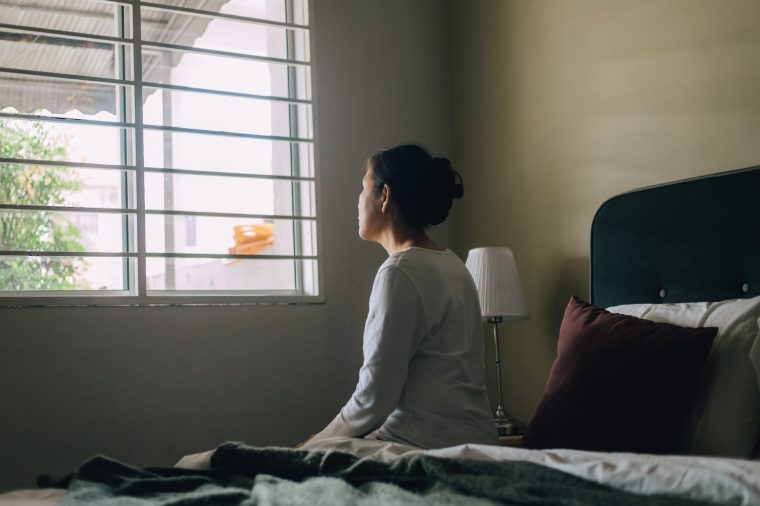 Elderly woman sitting alone in her living room - stock photo