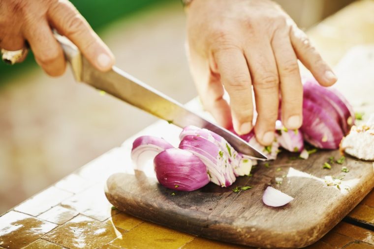 Close up shot of man chopping onions during cooking class - stock photo