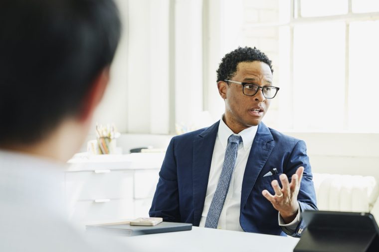 Medium shot of businessman leading meeting in office conference room - stock photo