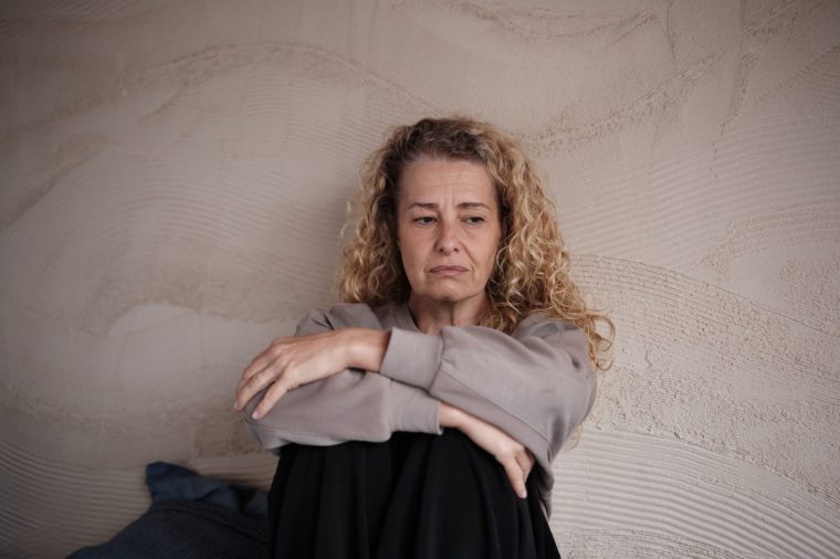 Midlife depression. Sad upset middle aged woman at home, feeling lonely. Aging anxiety and loneliness concept - stock photo