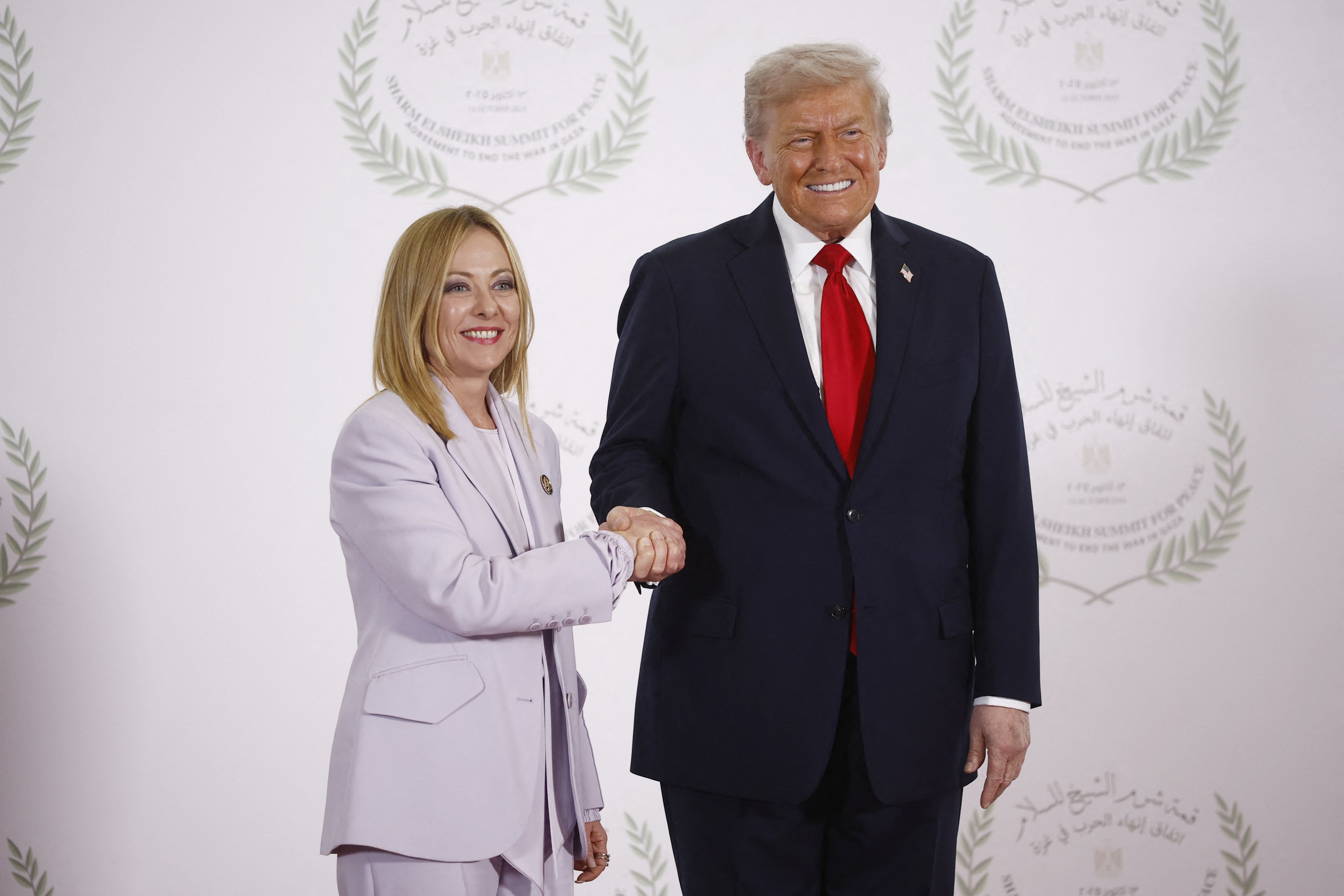 Italy's Prime Minister Giorgia Meloni (L) and US President Donald Trump shake hands during the greetings ceremony at the Gaza Peace Summit in Sharm El-Sheikh, on October 13, 2025