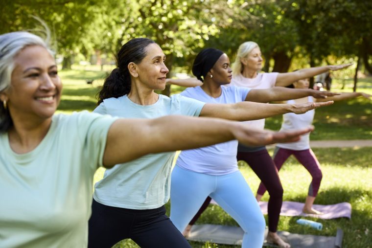 Active woman doing stretching exercise with friends - stock photo