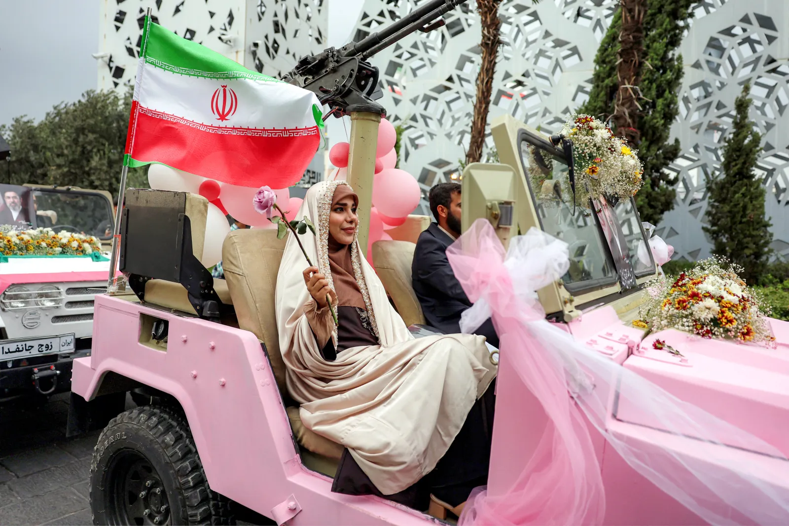 A bride and groom ride in a military jeep arriving for a public mass wedding ceremony at Imam Hossein Square in Tehran on May 18.