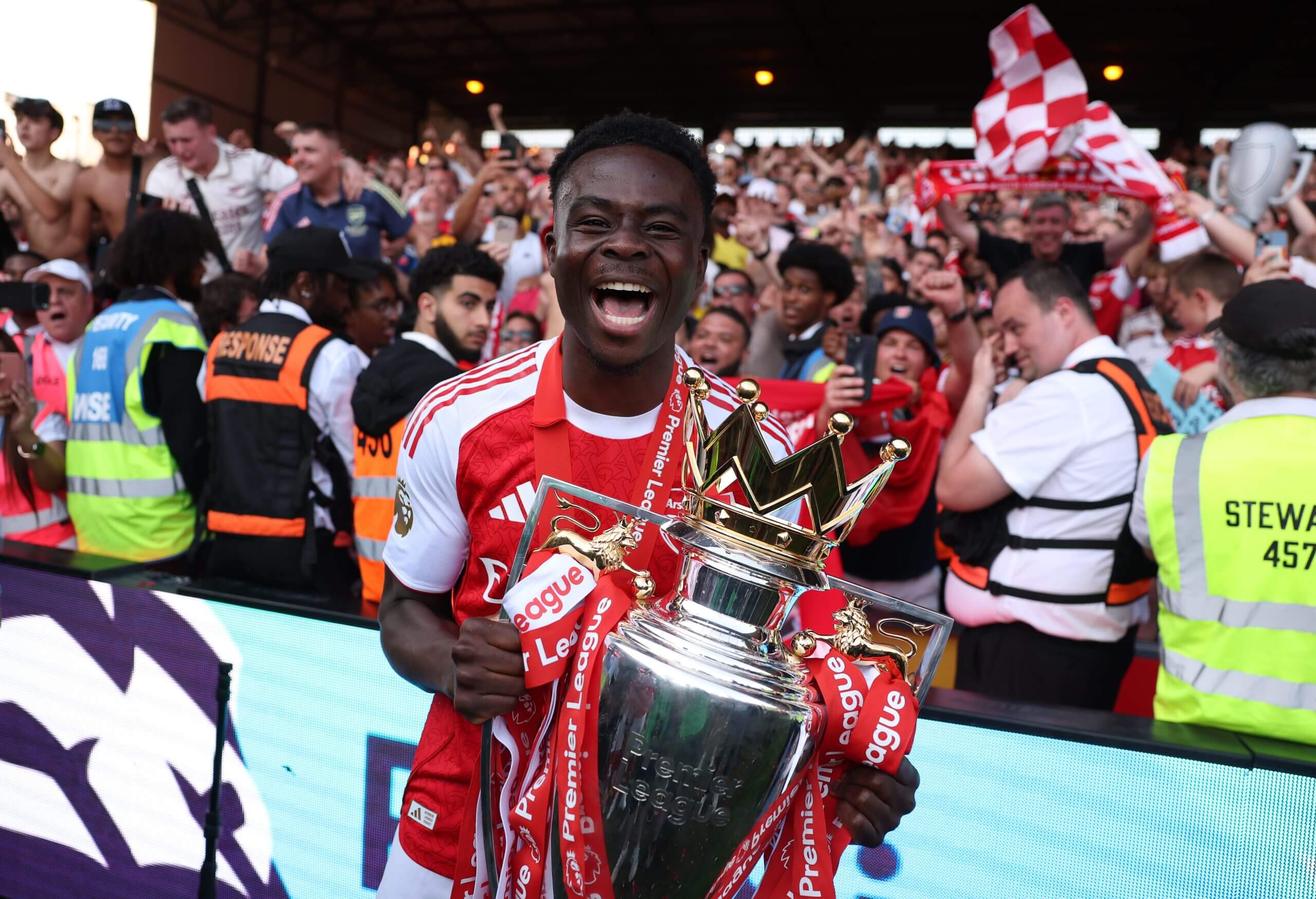 A delighted Bukayo Saka holds the Premier League trophy at Selhurst Park