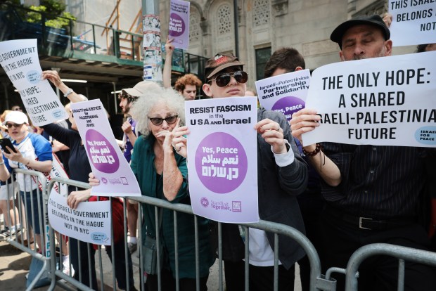 NEW YORK, NEW YORK - MAY 31: A small group of protesters watches as thousands of Jewish and Israeli Americans participate in the annual Israeli Day Parade, the world's largest pro-Israel parade, on May 31, 2026, in New York City. This year's event takes place under heightened security with hundreds of police, K-9 units, and undercover officers patrolling the route up 5th Avenue. New York City mayor Zohran Mamdani did not attend the parade, the first mayor in recent history not to do so. (Photo by Spencer Platt/Getty Images)
