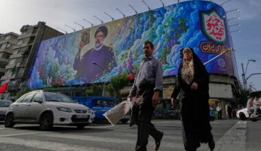 People cross an intersection in front of a billboard showing a portrait of the late Iranian President Ebrahim Raisi, who was killed in a helicopter crash in 2024, in downtown Tehran, Iran, Thursday, May 28, 2026. (AP Photo/Vahid Salemi)