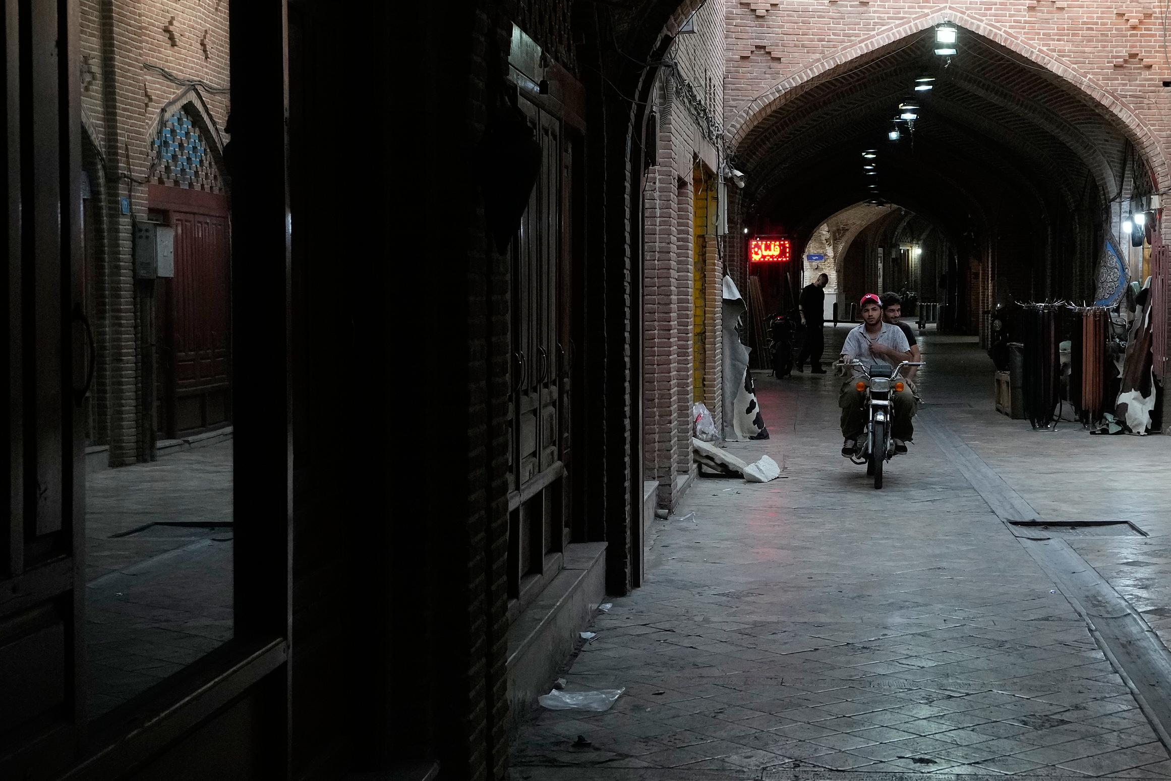 Men ride on their motorbike at the historic neighborhood of Oudlajan in Tehran, Iran.