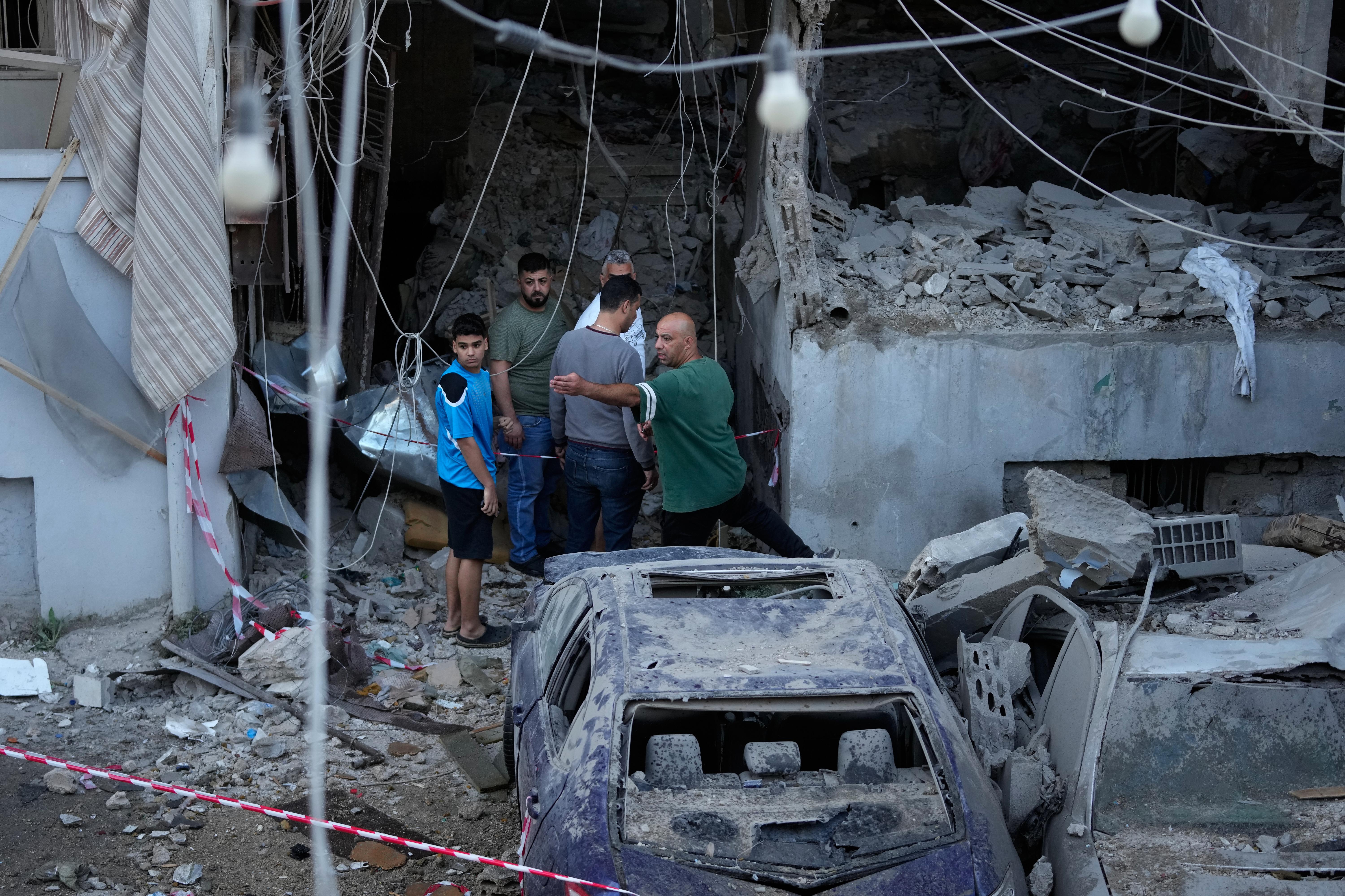 People gather outside a destroyed apartment that was hit in an Israeli airstrike.