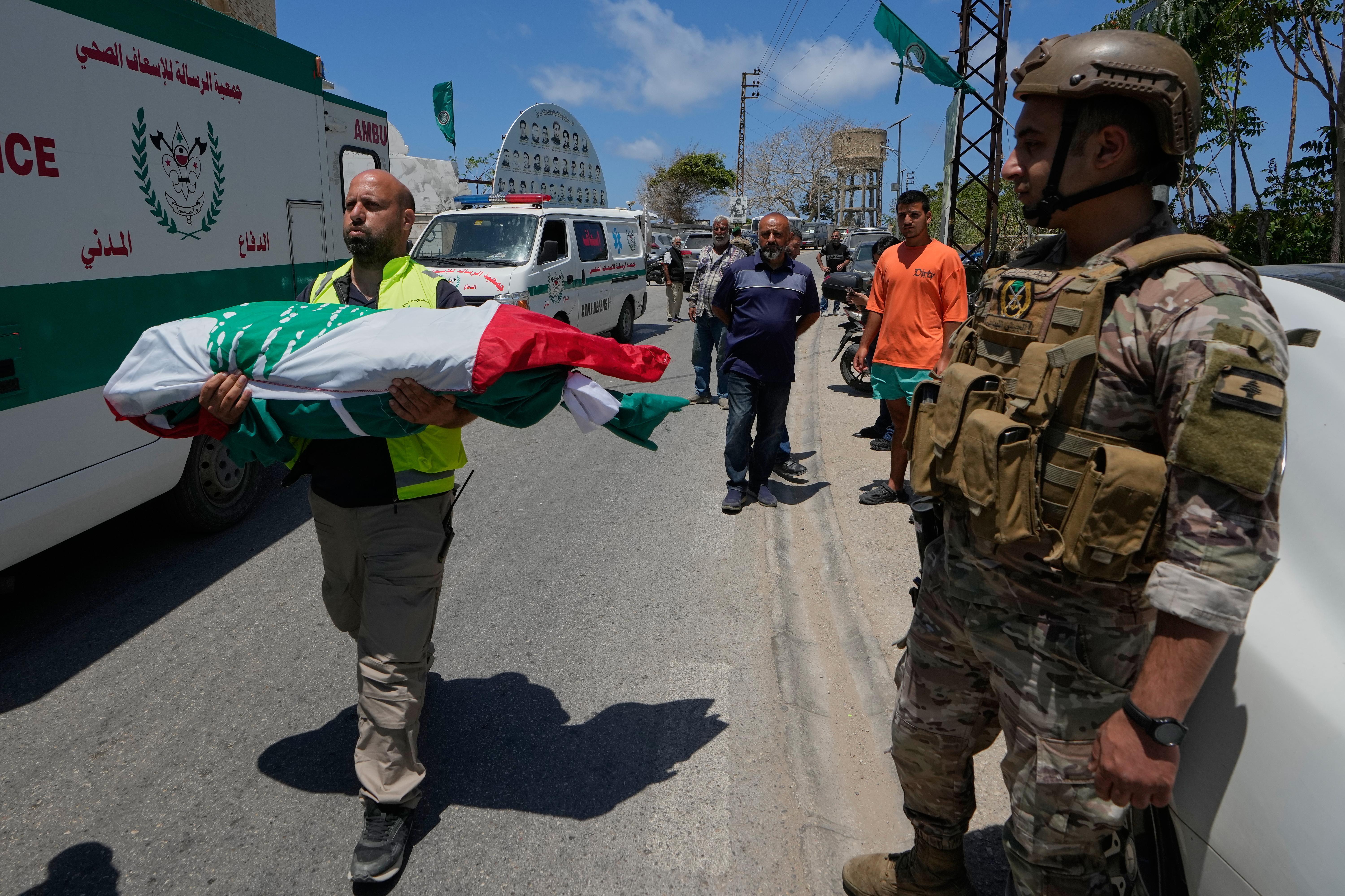 Mourners and paramedics carry the bodies of family members killed by Israeli airstrike