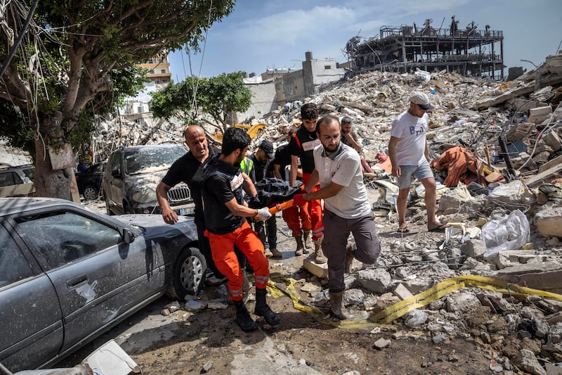 A body is removed from the rubble of a building in Tyre, Lebanon, destroyed in an Israeli airstrike. Photograph: David Guttenfelder/The New York Times
                      