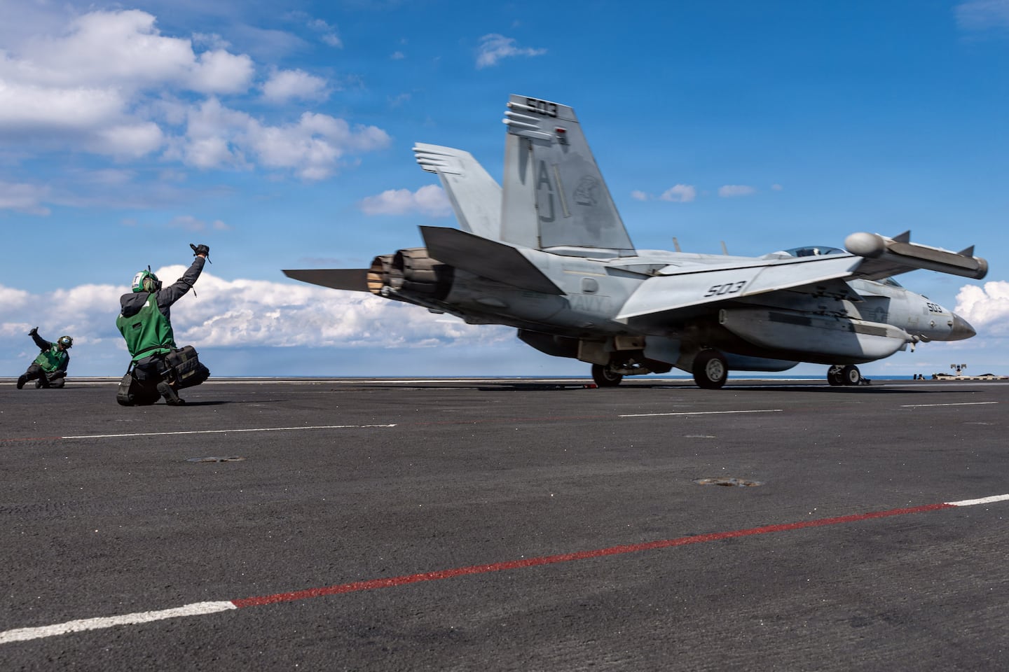 This image provided by US Central Command shows a Navy sailor signaling the launch of a EA-18G Growler on the USS Gerald R. Ford, on Sunday, March 1.