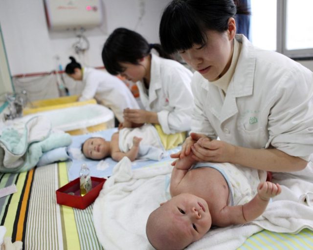 (FILES) This file photo taken on December 15, 2016 shows nurses massaging babies at an infant care centre in Yongquan, in Chongqing municipality, in southwest China. - China's birth rate dropped last year, 2019, to its lowest level since the Communist country was founded in 1949, adding to concerns that an ageing society and shrinking workforce will pile pressure on a slowing economy. (Photo by STR / AFP) / China OUT (Photo by STR/AFP via Getty Images)
