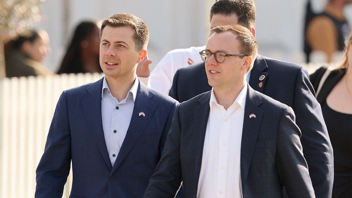 Secretary of Transportation Pete Buttigieg and husband Chasten Buttigieg standing at a reception in The Hague