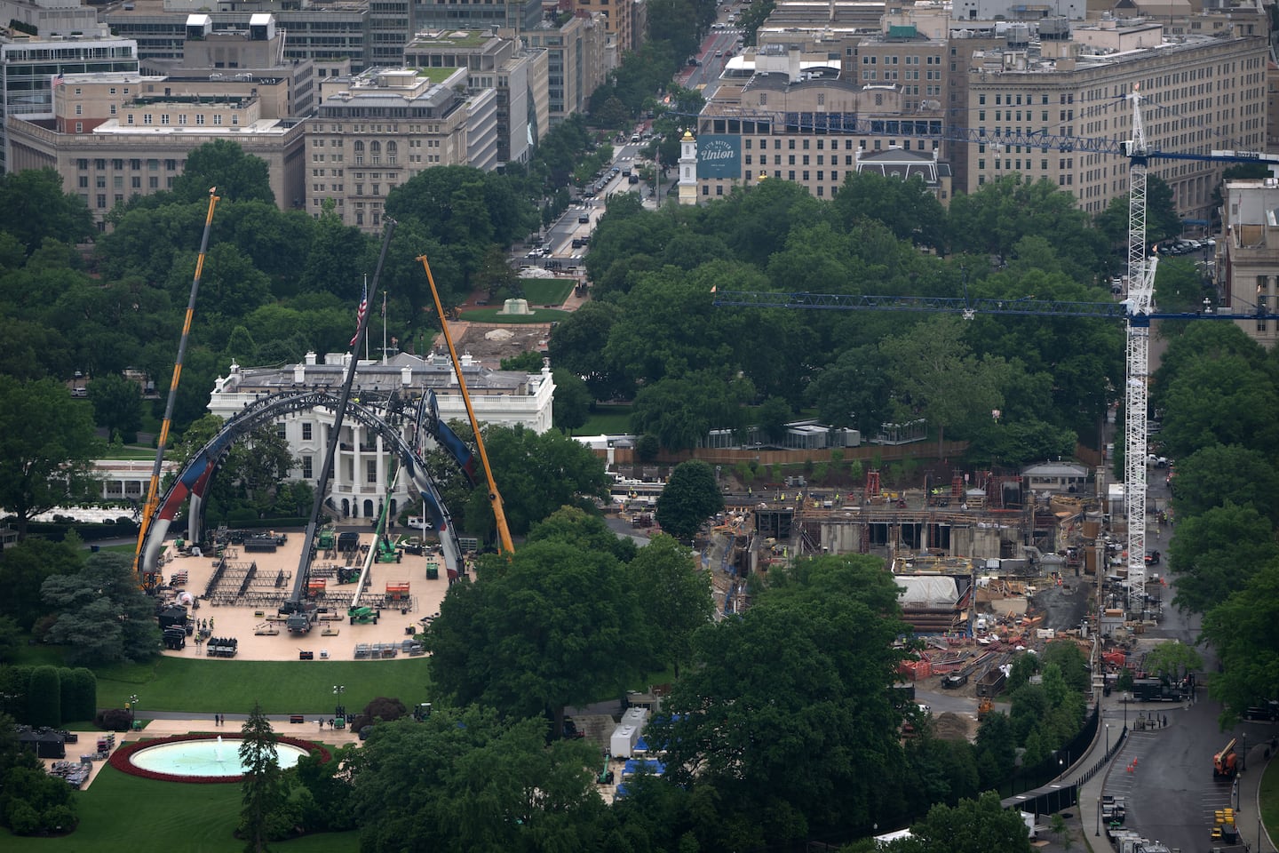 Equipment for a future UFC fight was placed on the South Lawn in front of the White House, on Tuesday, as construction on President Trump's ballroom (right) continued.