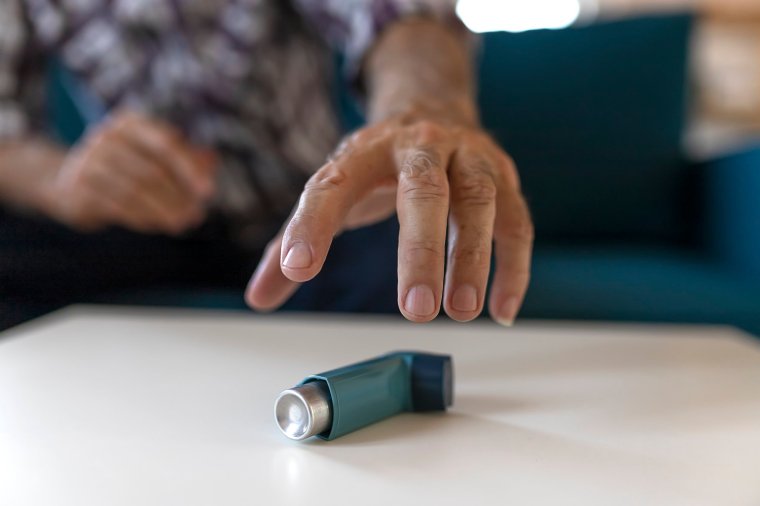 Man Hand Reaching Inhaler Because He Suffering From Asthma Attack Sitting on a Couch in the Living Room at Home