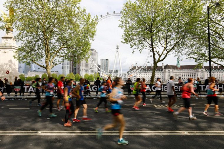 Competitors in the London Marathon run along The Embankment with the London Eye seen in the background