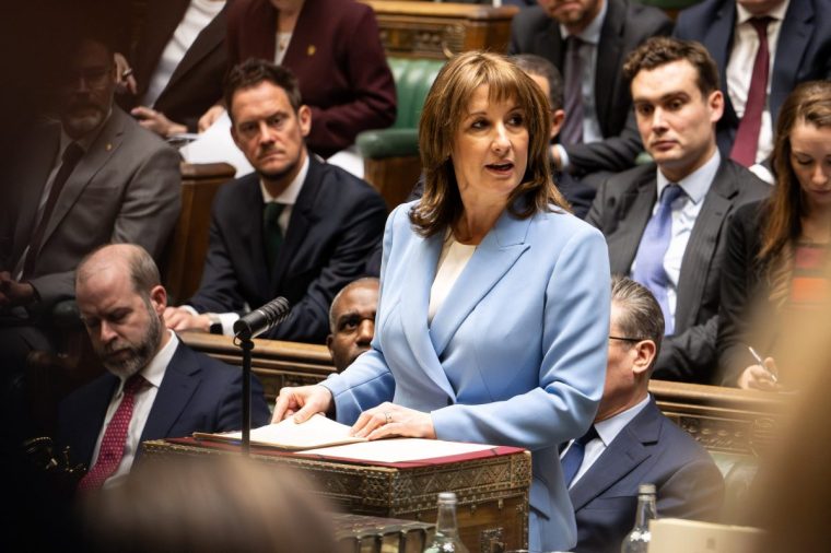 A handout photograph taken and released by the UK Parliament's House of Commons on March 3, 2026, shows Britain's Chancellor of the Exchequer Rachel Reeves delivering her Spring Budget Statement in the House of Commons. The UK government cut its 2026 growth forecast on Tuesday, as Britain's finance minister delivered a fiscal update overshadowed by concerns over the economic fallout from the Iran war. The Spring Statement spending update came as the Labour government struggles to boost sluggish economic growth, now threatened further by the widening Middle East conflict pushing up energy prices. (Photo by House of Commons / AFP via Getty Images) / RESTRICTED TO EDITORIAL USE - MANDATORY CREDIT " AFP PHOTO / House of Commons " - NO USE FOR ENTERTAINMENT, SATIRICAL, MARKETING OR ADVERTISING CAMPAIGNS - EDITORS NOTE THE IMAGE MAY HAVE BEEN DIGITALLY ALTERED AT SOURCE TO OBSCURE VISIBLE DOCUMENTS