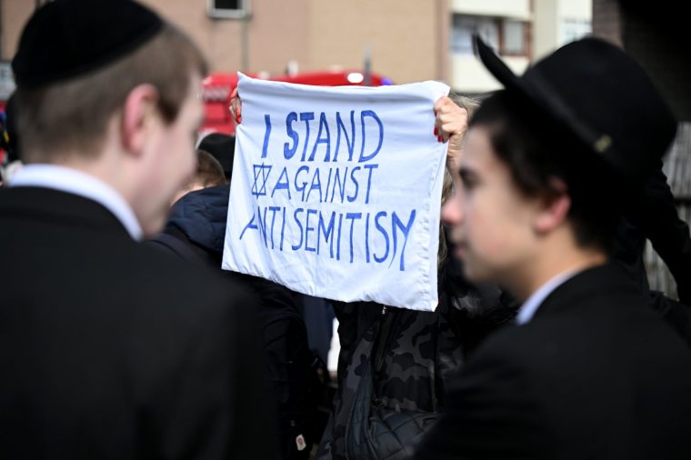LONDON, ENGLAND - MARCH 23: A member of the community holds up a banner reading 