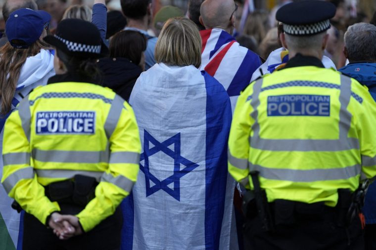 Metropolitan Police officers stand on duty as people attend a rally organised by the Campaign Against Antisemitism, opposite Downing Street in central London on April 30, 2026, following the stabbing of two Jewish men the day before in the Golders Green neighbourhood of north London. UK Prime Minister Keir Starmer vowed Thursday to boost security for the Jewish community following the latest attack against it, while urging Britons to unite against antisemitism. Facing accusations from angry British Jews that his government has repeatedly failed to protect them, Starmer pledged immediate increased funding for synagogues and other sites but insisted UK society must 