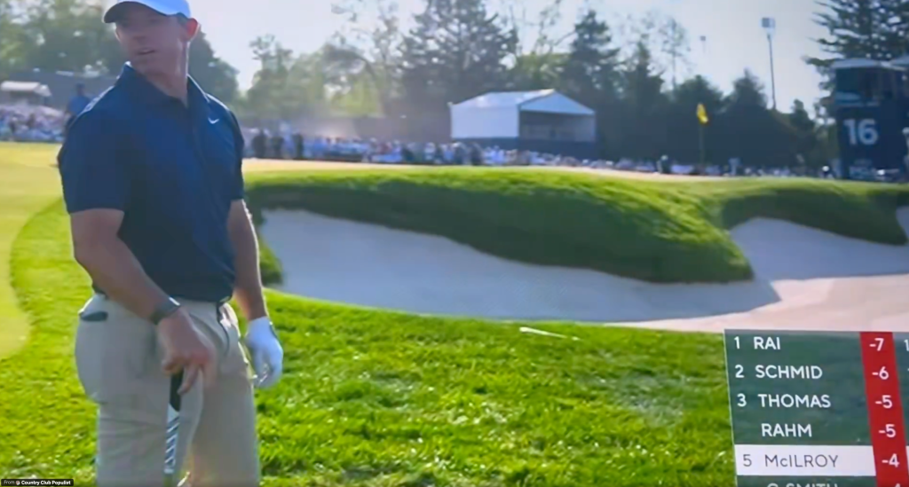 Rory McIlroy looks at the golf course, with a leaderboard showing him in fifth place.