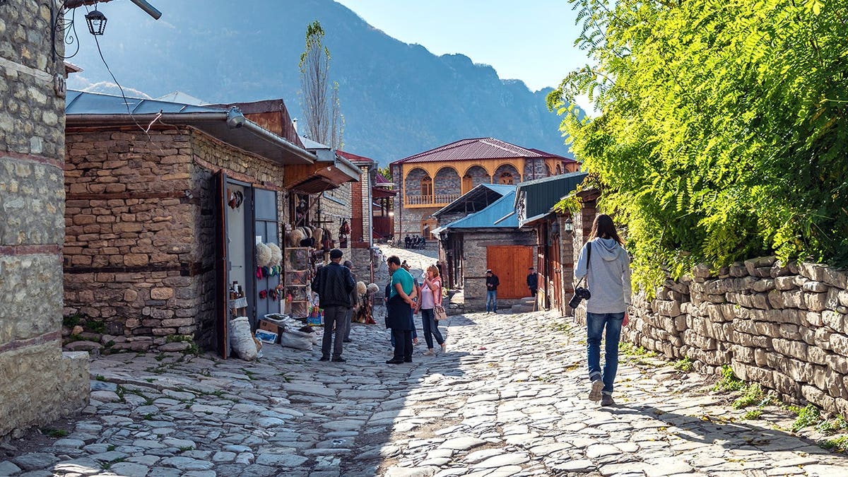 Woman walking down rural street in Azerbaijan