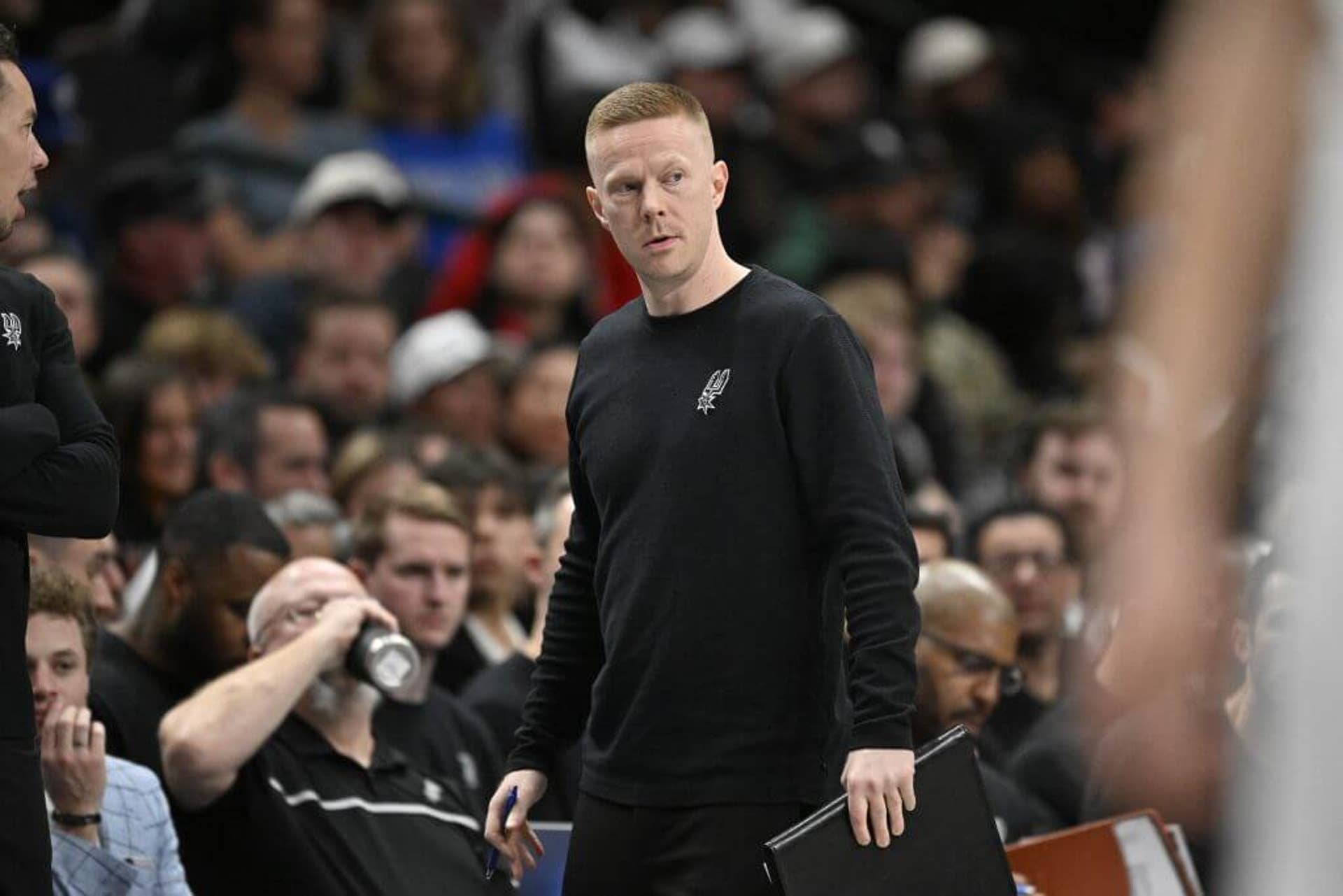 Sean Sweeney looks on during a Spurs game.