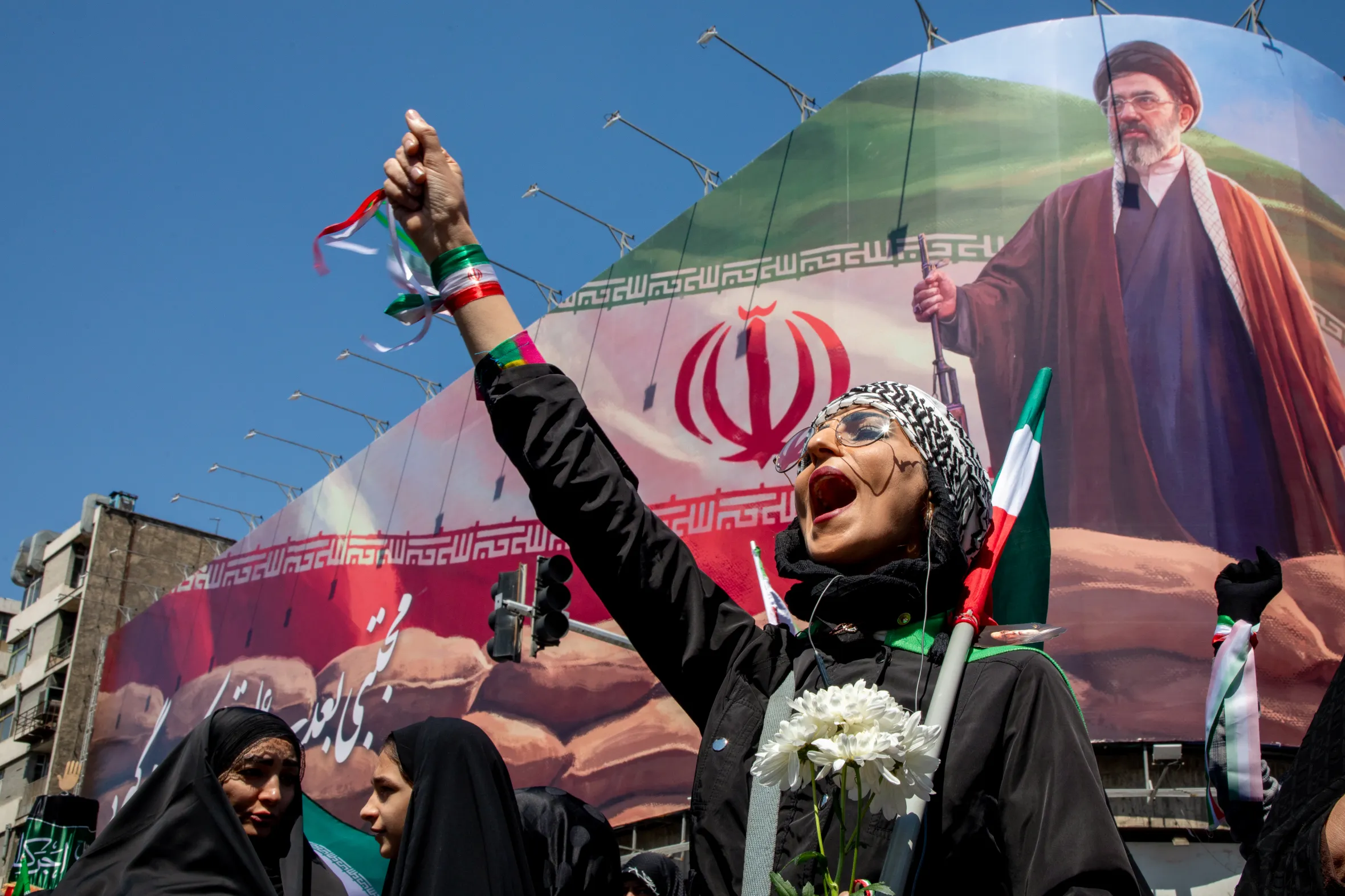 People gather under a large portrait of Iran's new Supreme Leader, Mojtaba Khamenei, during a memorial in Tehran, Iran.