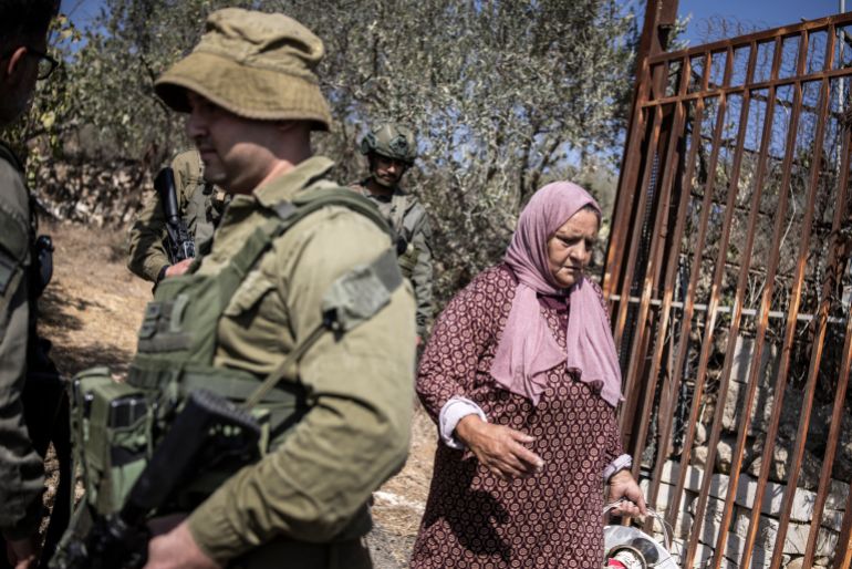 Israeli soldiers block the entrance to a Palestinian olive field near the Israeli settlement of Elazar south of Bethlehem in the occupied West Bank on October 17, 2025.