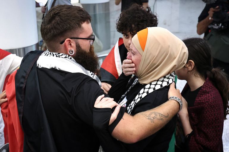 Members of a Gaza-bound flotilla, that were detained by Israeli security forces last week, hug family members and friends after arriving at Sydney International Airport on May 25, 2026.